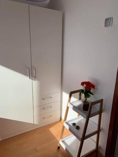 a room with a cabinet and a shelf with a vase of flowers at Apartman Mare Blace in Blace