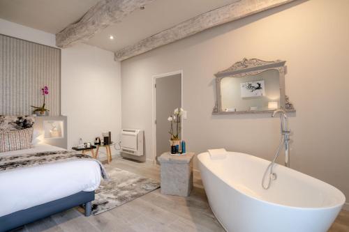 ein Schlafzimmer mit einem Bett und einer Badewanne in einem Zimmer in der Unterkunft Domaine De L´Oiseau in Gergy