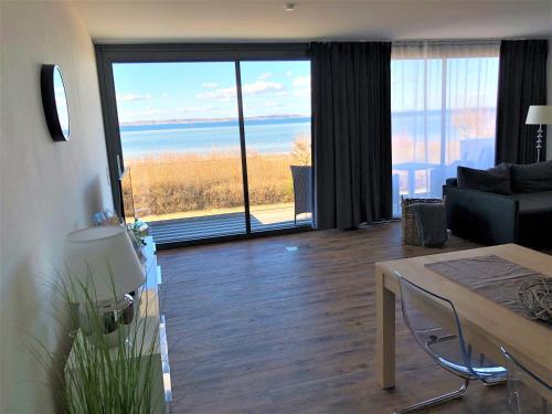 a living room with a table and a view of the ocean at Meeresrauschen in Laboe