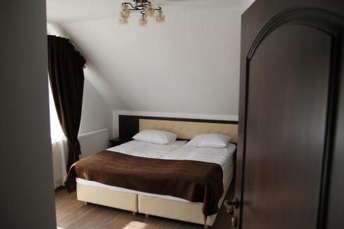 a bedroom with a bed and a chandelier at Купецький Двір in Mizhhirʼʼya