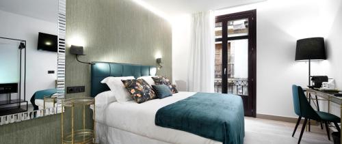 1 dormitorio con 1 cama con cabecero azul en Pension Ama Bilbao, en Bilbao