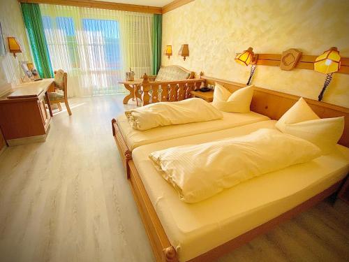 a bedroom with a large bed with a desk and a desk at Meister BÄR HOTEL Frankenwald in Berg