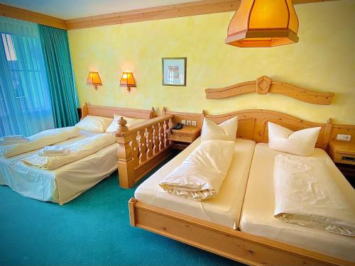 two twin beds in a room with two lamps at Meister BÄR HOTEL Frankenwald in Berg