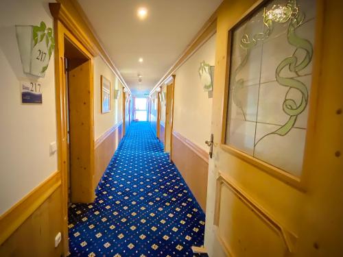 a hallway in a hotel with a blue floor at Meister BÄR HOTEL Frankenwald in Berg