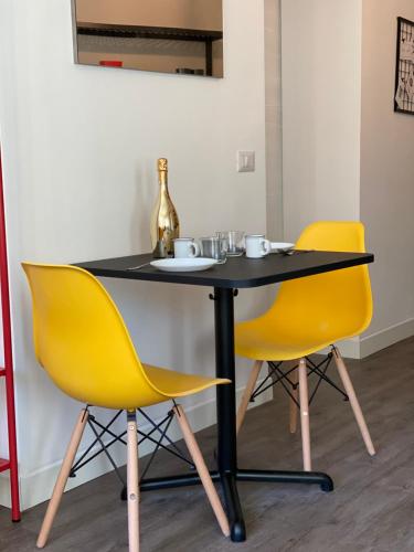 a table with two yellow chairs and a bottle on it at VANNUCCI 71 APT in Perugia