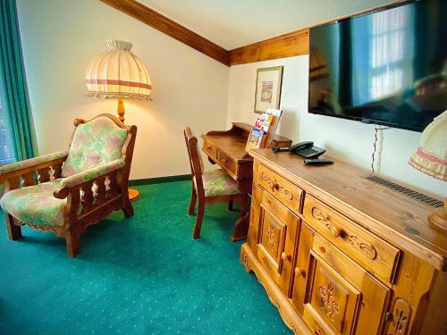 a living room with a large television and a desk at Meister BÄR HOTEL Frankenwald in Berg