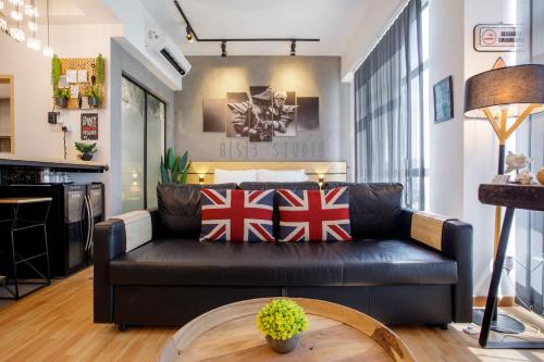 a living room with a black leather couch at AISI3 Studio Seaview at Tanjung Lumpur in Kuantan