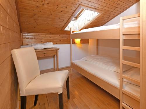 a bedroom with bunk beds and a desk and a chair at Hotel St Hubertus in Egg