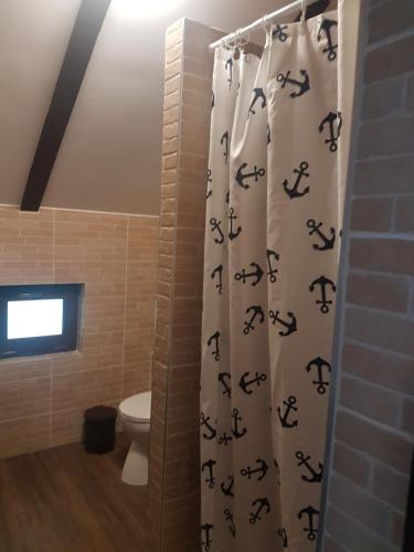 baño con aseo y cortina de ducha con alfabeto en La Lorica in Bucovina, en Mănăstirea Humorului