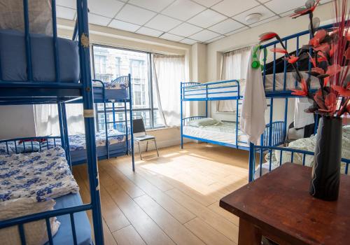 a room with several bunk beds and a table at The Apache Hostel in Dublin