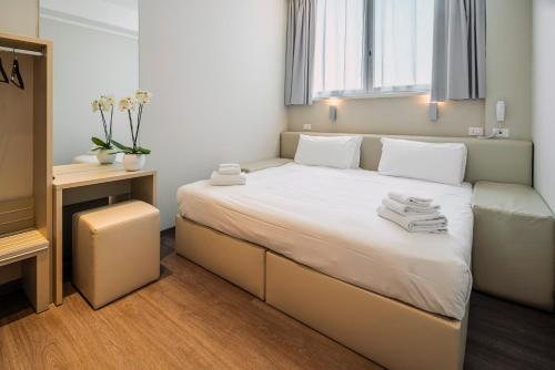 a bedroom with a large bed with towels on it at Fasthotel Linate in Segrate