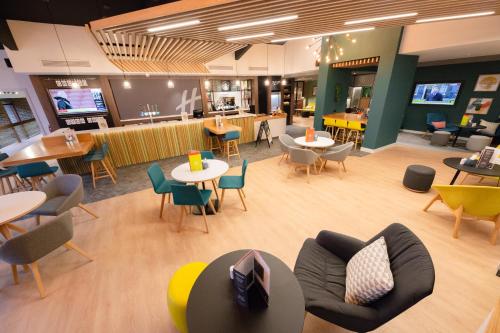 a lobby with tables and chairs and a cafeteria at Holiday Inn Newport, an IHG Hotel in Newport