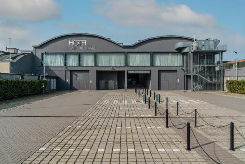a building with a row of poles in front of it at Fasthotel Linate in Segrate