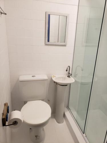 a white bathroom with a toilet and a sink at Pousada Recanto dos Nativo in Paraty
