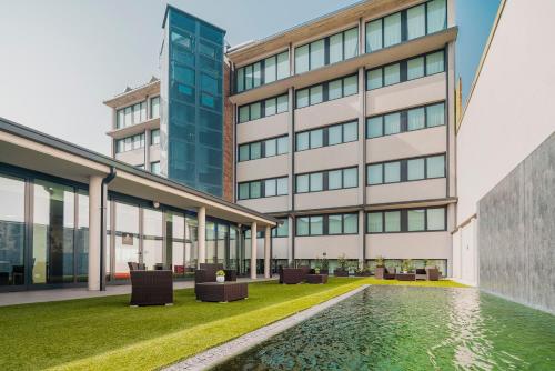 an office building with a pool in front of it at Fasthotel Linate in Segrate