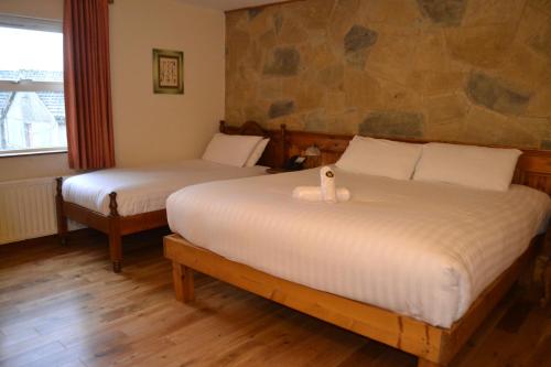 Ένα ή περισσότερα κρεβάτια σε δωμάτιο στο Walsh's Hotel and Apartments