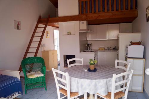 une cuisine et une salle à manger avec une table et des chaises dans l'établissement Petite maison reposante pour 2 au bord de mer, à Bretignolles-sur-Mer
