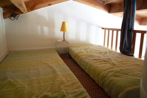 a bedroom with two beds and a lamp in a room at Petite maison reposante pour 2 au bord de mer in Brétignolles-sur-Mer