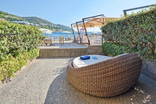 a large wicker tub sitting on a brick walkway next to the beach at Hotel Riviera dei Fiori in San Lorenzo al Mare