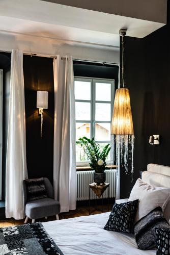 a bedroom with a bed and a chair and a window at charme et standing centre ville in Barcelonnette