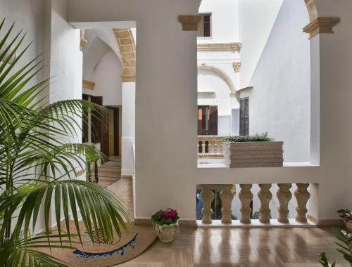 a hallway of a house with a palm plant at Al Pescatore Hotel & Restaurant in Gallipoli