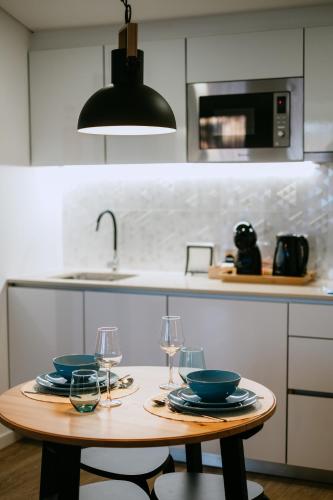 a kitchen with a table with plates and wine glasses at Villa Teresa apartamentos in Vila Nova de Gaia
