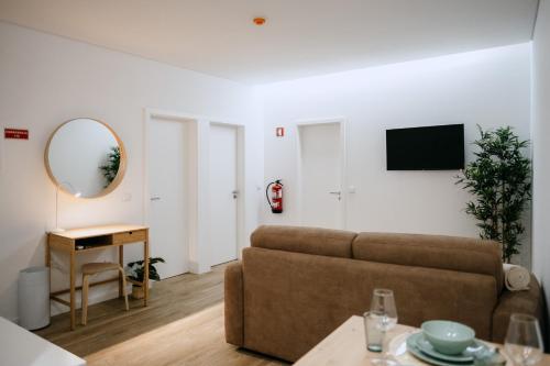 a living room with a couch and a mirror at Villa Teresa apartamentos in Vila Nova de Gaia