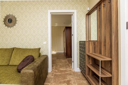 a living room with a couch and a mirror at Sakura_INN Palanga in Palanga