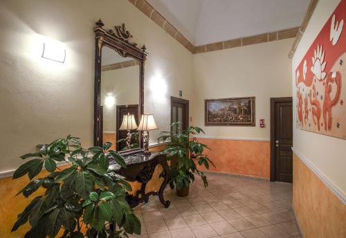 a hallway with a mirror and a potted plant at Al Pescatore Hotel & Restaurant in Gallipoli