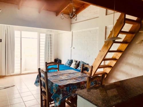 een woonkamer met een tafel en een trap bij Alojamiento PISCIS in Puerto Madryn