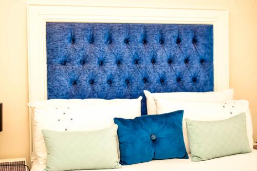 a bed with two pillows and a blue headboard at Villa Palesa Guesthouse in Grahamstown