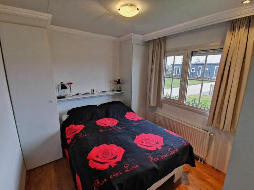 Un dormitorio con una cama con rosas rojas. en Giet Oan gelegen op Resort Venetië, en Giethoorn