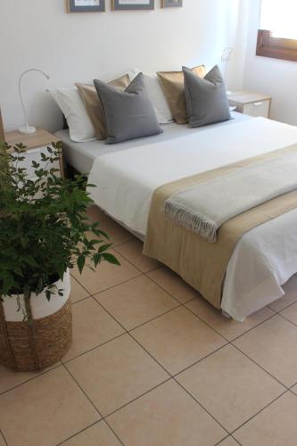 ein Schlafzimmer mit einem großen Bett und einer Topfpflanze in der Unterkunft Casa Vacanze Giorgetta 2-3 piano in Chioggia
