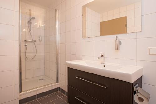 La salle de bains est pourvue d'un lavabo et d'une douche. dans l'établissement Fletcher Hotel Restaurant Prinsen, à Vlijmen