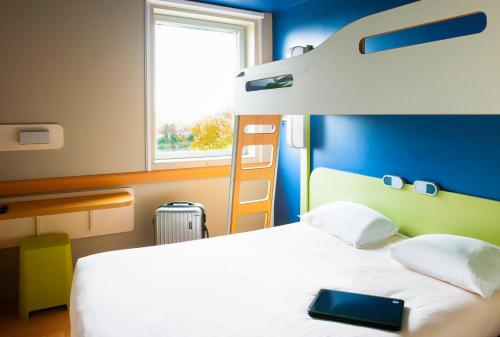 a bedroom with a bed and a bunk bed at Ibis Budget Cergy St Christophe in Cergy