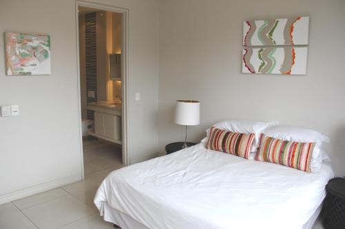 1 dormitorio con cama blanca y almohada en The Emperor, en Johannesburgo