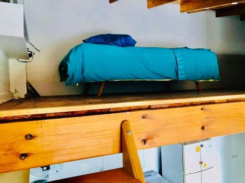 una cama sobre una mesa de madera en Alojamiento PISCIS en Puerto Madryn