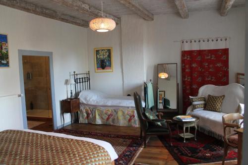 a bedroom with a bed and a couch and a table at L'Ancienne Ecole in Vernassal