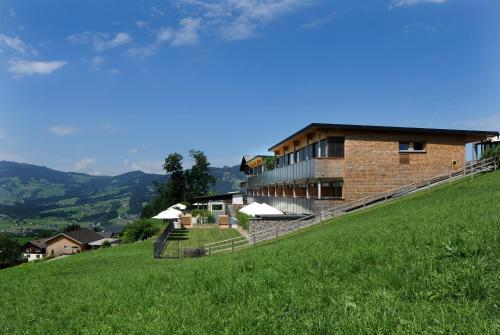 a building on the side of a grassy hill at Hotel St Hubertus in Egg