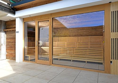 a wooden pivot door with glass panels in a house at Hotel St Hubertus in Egg