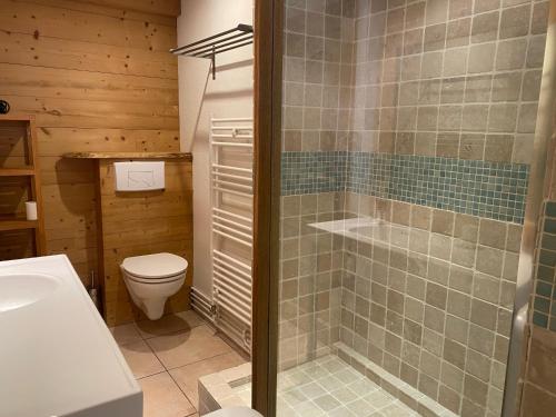 uma casa de banho com um WC, um chuveiro e um lavatório. em Le REFUGE véritable cocon avec Cheminée em Les Orres