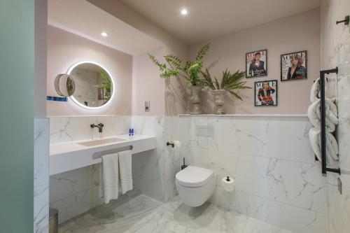 a white bathroom with a toilet and a sink at Waterfront Southport Hotel in Southport