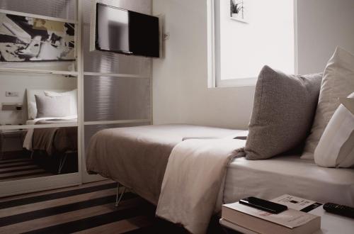 a bedroom with a bed and a tv on a wall at room Select Sol in Madrid
