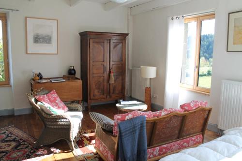 a living room with a couch and chairs and a cabinet at L'Ancienne Ecole in Vernassal