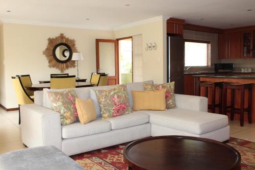 a living room with a white couch and a table at Topaz Cove Luxury Villas in Edenvale