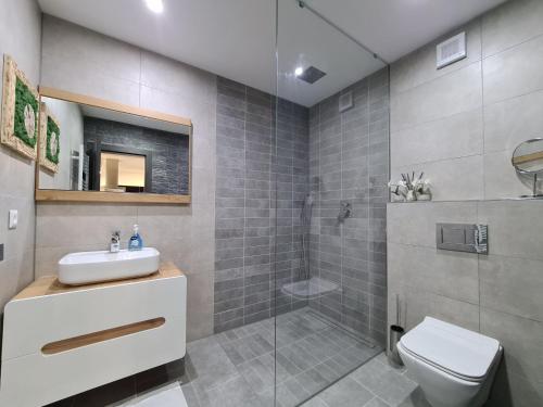 a bathroom with a toilet and a sink and a shower at 365 apartmány LINEA in Piešťany