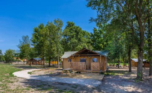 a cabin in a park with a bench and trees at Agriturismo Tenuta Regina - Glamping luxury lodges and apartments in Palazzolo dello Stella