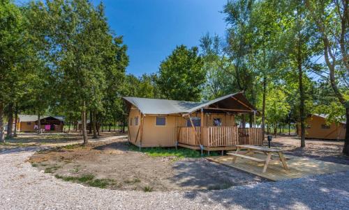 a small cabin with a table and a tent at Agriturismo Tenuta Regina - Glamping luxury lodges and apartments in Palazzolo dello Stella