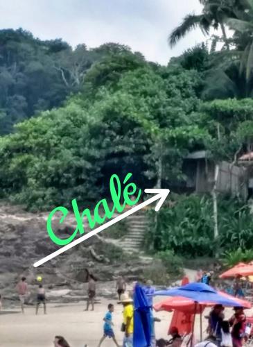 a group of people on a beach with a sign that says chale at Chalé na Praia da Tiririca in Itacaré