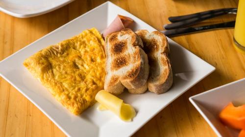 a plate of breakfast food with toast and cheese at Medellín Vibes Hostel in Medellín